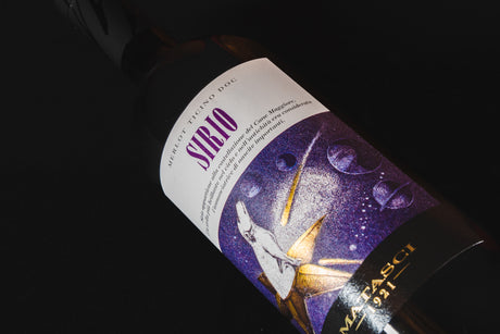 bottiglia di Sirio adagiata su fondale nero si vede in primo piano l'etichetta , vino merlot